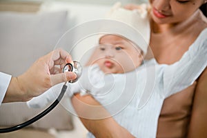 An adorable baby being checked by a doctor using a stethoscope. Childcare concept