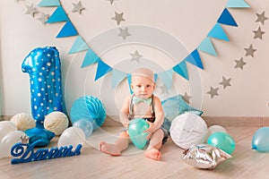 Adorable baby boy celebrating his first birthday. Smash cake