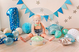 Adorable baby boy celebrating his first birthday. Smash cake