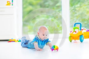 Adorable baby boy with colorful ball and toy car