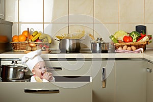 Adorable baby boy in kitchen