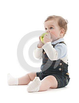 Adorable baby boy sit and eat green apple