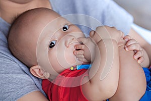 Adorable baby boy sucking his toes