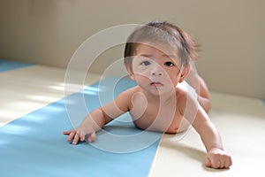 Adorable baby boy trying crawl clamber first time