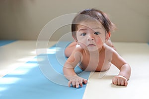 Adorable baby boy trying crawl clamber first time photo