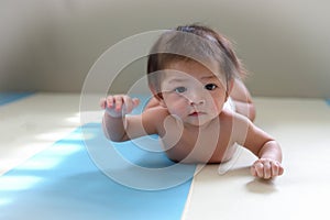 Adorable baby boy trying crawl clamber first time photo