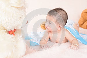 Adorable baby boy in white sunny bedroom.