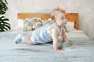 Adorable baby boy in white sunny bedroom. Textile and bedding for kids. Family morning at home