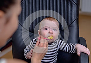 Adorable Baby on Chair Eating Porridge Food