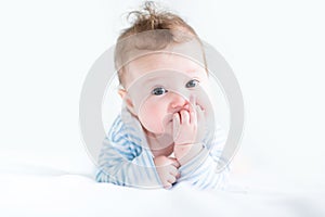 Adorable baby doing her tummy time in a white nursery