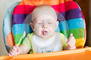 Adorable baby eating in high chair