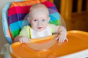 Adorable baby eating in high chair