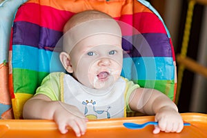 Adorable baby eating in high chair