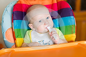 Adorable baby eating in high chair