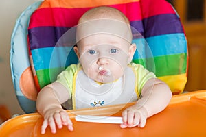 Adorable baby eating in high chair