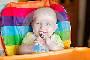 Adorable baby eating in high chair