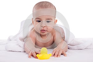 Adorable baby enjoy and looking at yellow duck after bath