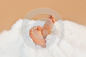 Adorable baby feet wrapped in a white blanket, maternity and babyhood concept