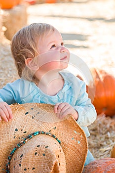 Adorable Baby Girl with Cowboy Hat in a Country Rustic Setting at the Pumpkin Patch