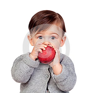 Adorable baby girl eating a red apple