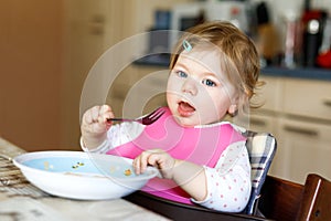 Adorable baby girl eating from spoon mashed vegetables and puree. food, child, feeding and people concept