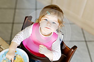 Adorable baby girl eating from spoon mashed vegetables and puree. food, child, feeding and people concept