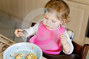 Adorable baby girl eating from spoon mashed vegetables and puree. food, child, feeding and people concept