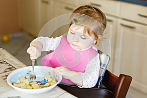 Adorable baby girl eating from spoon mashed vegetables and puree. food, child, feeding and people concept