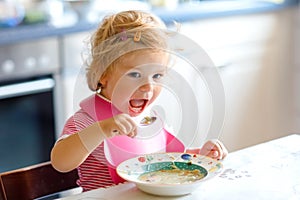 Adorable baby girl eating from spoon vegetable noodle soup. food, child, feeding and development concept. Cute toddler