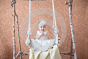 Adorable baby girl enjoying ride in a swing home