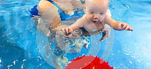 Adorable baby girl enjoying swimming in a pool with her mother early development class for infants teaching children to