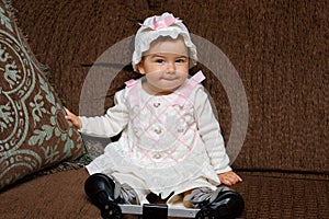 Adorable Baby Girl in Eyelet Dress and Hat Poses for the Camera