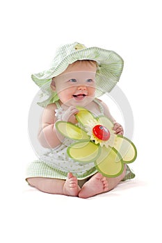 Adorable baby girl holds her toy flower