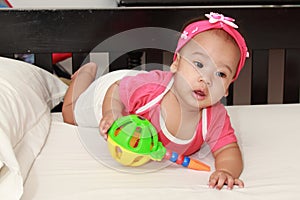 Adorable baby girl infant playing toy at nursery