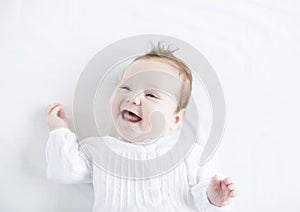 Adorable baby girl laughing toothless on a white b photo