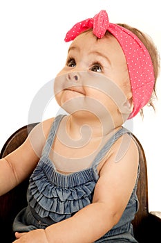 Adorable baby girl looking up wearing a pink headband