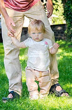 Adorable baby girl making first steps