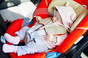 Adorable baby girl in modern car seat