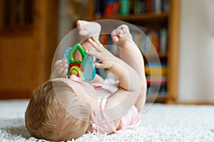 Adorable baby girl playing with educational toys in nursery