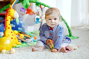 Adorable baby girl playing with educational toys in nursery