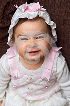 Adorable Baby Girl Smiling With a Scrunched Face She is Wearing photo