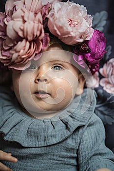 Adorable baby girl wearing wreath.
