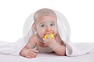 Adorable baby holding and bites yellow duck after shower