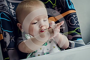 Adorable baby learning to feed himself for the first time