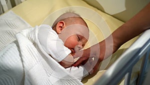 Adorable baby lying down on the bed at home. Newborn relaxing and sleeping comfortable