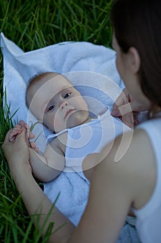 Adorable baby lying on the grass. Happy beautiful family.