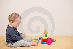 Adorable baby playing with educational toys . background with copy space. Happy healthy child having fun at home. Early