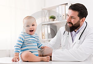 Adorable baby sitting with doctor at clinic