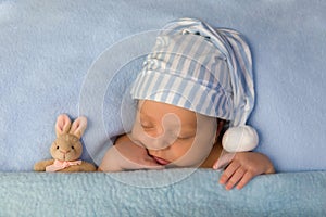 Adorable baby sleeping in blue bed