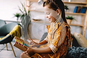 Adorable beautiful girl playing with educational wooden toy. Healthy happy kid learning to count